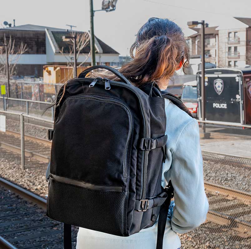 Lady waiting for a train wearing bullet proof backpack by BodyGuard